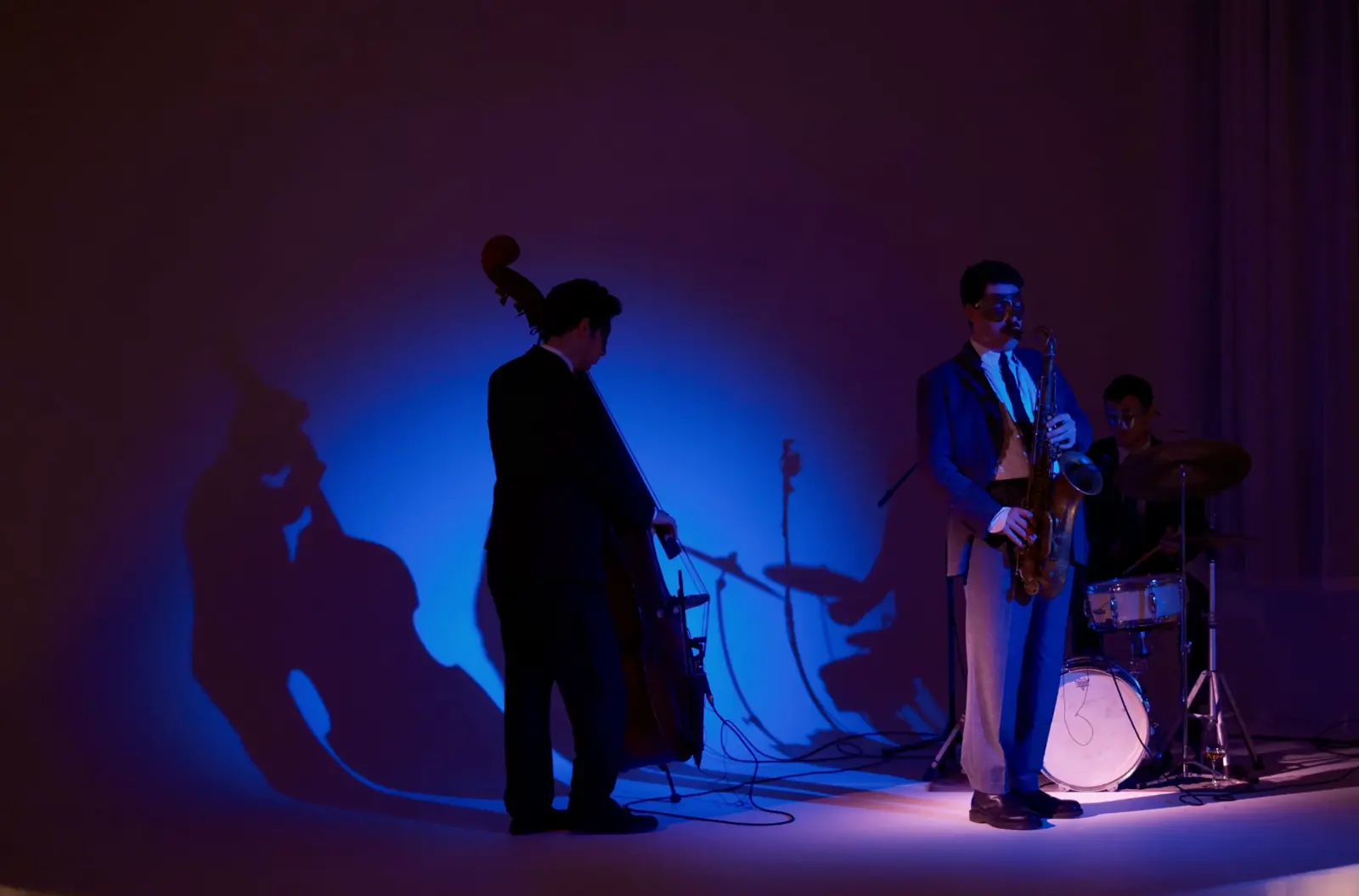 Jazz trio performing on a blue-lit stage